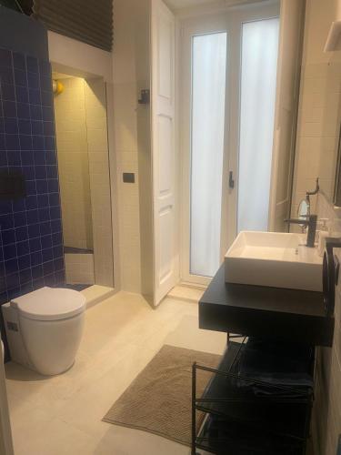 a bathroom with a white toilet and a sink at Il fiore Blue in Barletta