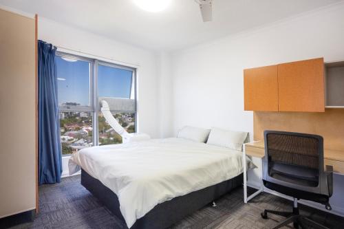 a bedroom with a bed and a desk and a chair at Shafston Service Apartment in Brisbane