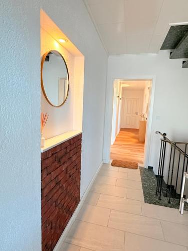 a hallway with a mirror and a brick wall at Ferienwohnung Auszeit in Arenborn