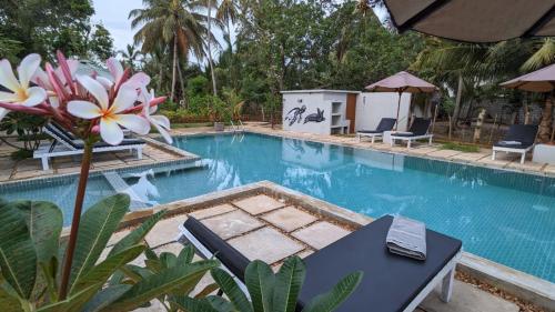a pool with a table and chairs and a flower at Lagoon gate Tangalle Resort in Tangalle