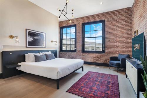 a bedroom with a bed and a brick wall at Roami at The Lola Convention Center Studio #11 in New Orleans