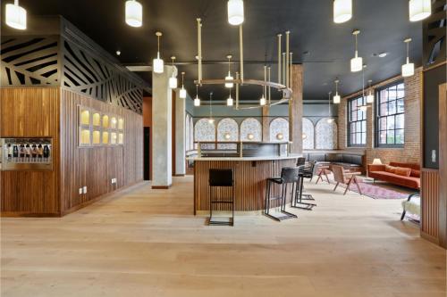 a large room with a bar with chairs and tables at Roami at The Lola Convention Center Studio #11 in New Orleans