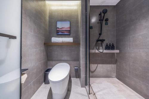 a bathroom with a toilet and a glass shower at Atour Hotel Shenyang Tiexi Plaza Qigong Street Subway Station in Shenyang