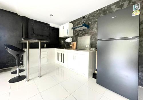 a kitchen with a stainless steel refrigerator and white cabinets at Quiet Seaview House 1 Bedroom Patong in Patong Beach