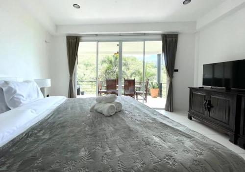 Un dormitorio con una cama con un osito de peluche encima. en Quiet Seaview House 1 Bedroom Patong, en Patong Beach