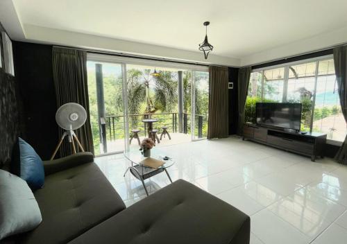 Una sala de estar con un sofá y un televisor. en Quiet Seaview House 1 Bedroom Patong, en Patong Beach