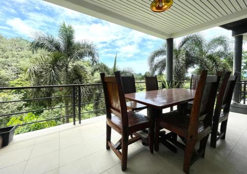 a dining room with a table and chairs on a balcony at Quiet Seaview House 1 Bedroom Patong in Patong Beach