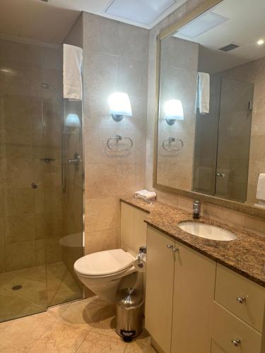 a bathroom with a toilet and a shower and a sink at Central Apartment BON21409 in Sydney