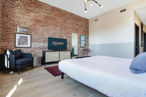 ein Schlafzimmer mit einem Bett und einer Ziegelwand in der Unterkunft Roami at The Lola Convention Center Studio #12 in New Orleans