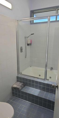 a bathroom with a shower and a sink and a toilet at Sundaise Satinay 636 at Kingfisher Bay Resort in K'gari Island (Fraser Island)