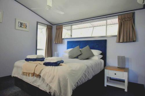 Un dormitorio con una cama grande y una ventana en Sundaise Satinay 636 at Kingfisher Bay Resort, en Fraser Island