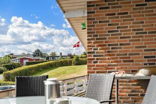 a table and chairs on a balcony with a brick wall at SJ301-Hejls-Teglgardsvej-3 in Hejlsminde