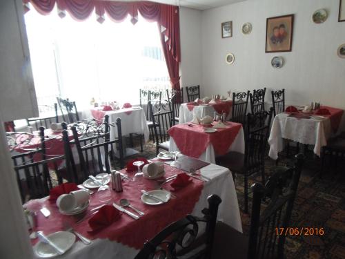ein Esszimmer mit Tischen und roten Tischdecken in der Unterkunft Oban House in Blackpool