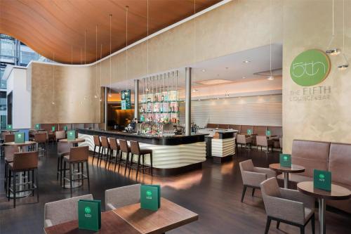 a restaurant with a bar and tables and chairs at Hilton Frankfurt Airport in Frankfurt