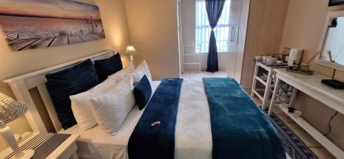 a bedroom with a large bed with blue and white pillows at 20 Seemeeu Vlug in Hartenbos