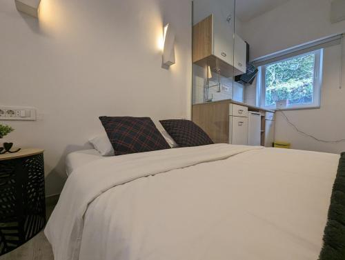 a bedroom with a large white bed in a room at Cowshed w Floor Heating in Ugly Duckling Courtyard in Zagreb