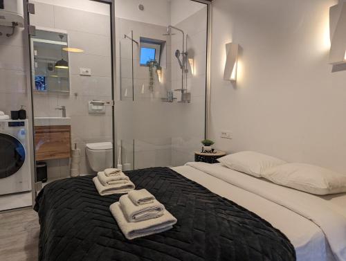 a bedroom with a large bed with towels on it at Cowshed w Floor Heating in Ugly Duckling Courtyard in Zagreb