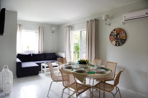 a living room with a table with chairs and a couch at Regalo Apartments in Lygia