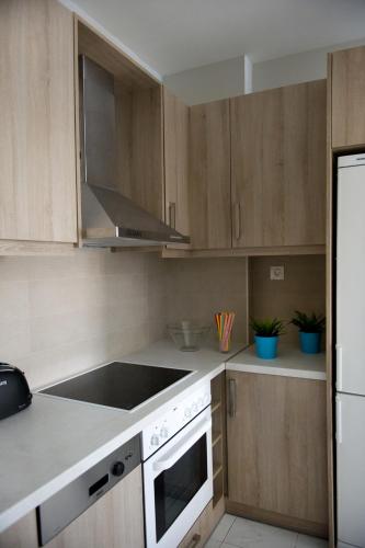 a kitchen with wooden cabinets and a stove top oven at Regalo Apartments in Lygia