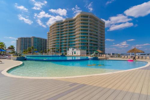 a swimming pool in front of a tall building at Caribe 213B in Orange Beach