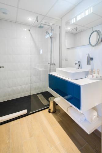a bathroom with a sink and a shower at Hôtel Le Rive Droite & SPA in Lourdes