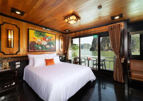 Un dormitorio con una cama blanca y una ventana. en Victory Boutique Cruise, en Ha Long