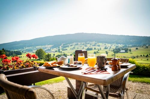 a table with food and glasses of orange juice at Domaine du Mont-Saint-Jean in Les Rousses