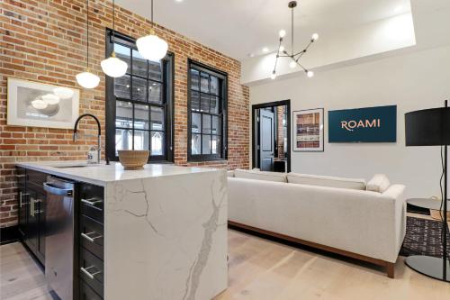 a kitchen and living room with a couch and a counter at Roami at The Lola Convention Center 1BR #13 in New Orleans