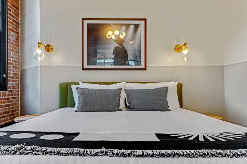 a bedroom with a bed with a picture on the wall at Roami at The Lola Convention Center 1BR #13 in New Orleans