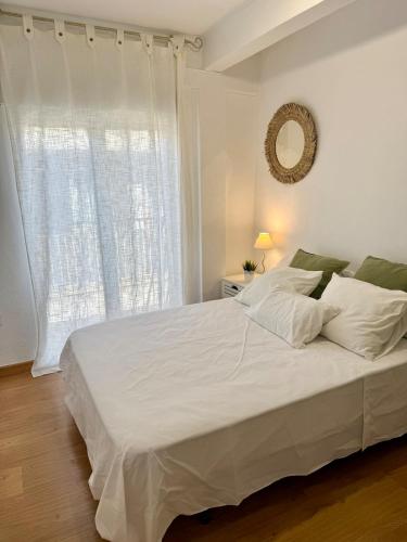a bedroom with a large white bed with a window at Fabuloso apartamento Catedral Centro Ciudad in Granada