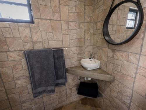 a bathroom with a sink and a mirror at Nauams Namibia - Farmyard Chalets, Mountain Cabins and Campsite in Namibgrens