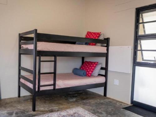 a couple of bunk beds in a room at Nauams Namibia - Farmyard Chalets, Mountain Cabins and Campsite in Namibgrens