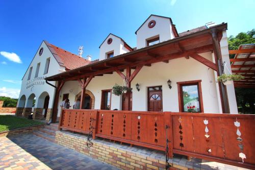 a building with a wooden fence in front of it at Gesztenyés Vendégház in Garáb