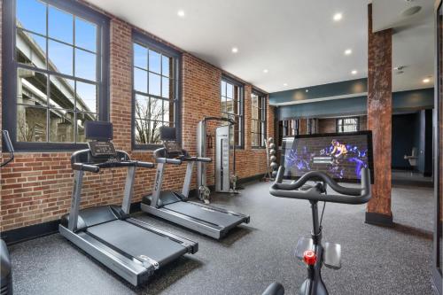 a gym with several tread machines and a tv at Roami at The Lola Convention Center 1BR #16 in New Orleans