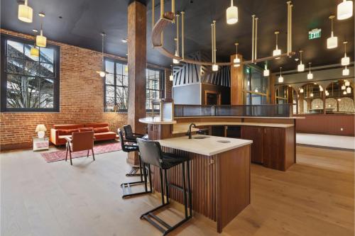 a kitchen with a bar with chairs and a couch at Roami at The Lola Convention Center 1BR #16 in New Orleans