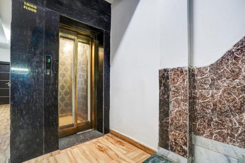 a bathroom with a door and a wall with marble at Hotel Twamev Couple Friendly Laxmi Nagar in New Delhi