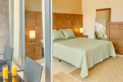a bedroom with a bed and a mirror at Jungle Guardian - Rooftop Pool & Beach Club in Zona Hotelera Tulum in Tulum