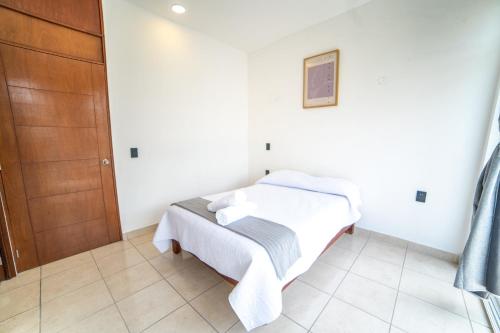 a bedroom with a bed in a white room at Hotel Catedral Jojutla in Jojutla