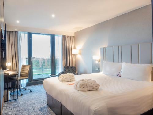 a hotel room with a bed with towels on it at Crowne Plaza London - Kingston by IHG in Kingston upon Thames