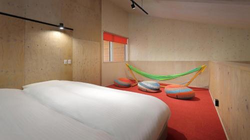 a bedroom with a bed and a hammock in it at Onsen Glamping ShimaBlue in Nakanojo
