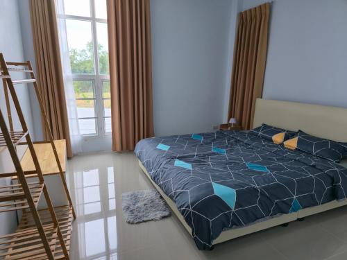 a bedroom with a bed with a blue comforter at Chiangmai Love U Villas in Chiang Mai