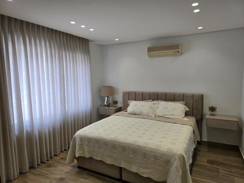 a bedroom with a bed and a window with curtains at Villa rooftop with stunning view apartment in Amman