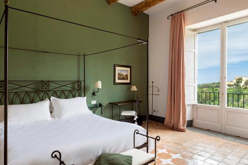 a bedroom with a large bed with a green wall at Relais Regina Giovanna in Sorrento