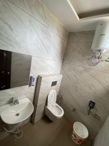 a bathroom with a sink and a toilet at Hotel Sommaya Grand in Ludhiana
