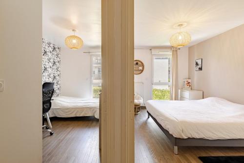 a bedroom with two beds and a room with two windows at Le Cocon de Beaumont - T3 Cozy in Beaumont