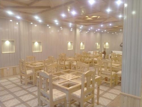 a dining room with tables and chairs and lights at Dumani Inn Hotel & Restaurant in Dargai