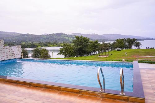 a swimming pool with a view of the water at De Soul Santé Pawna in Lonavala