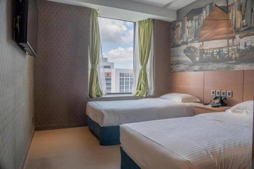 a hotel room with two beds and a window at Largos Hotel in Hong Kong