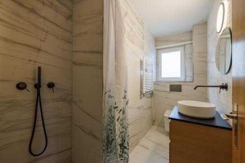 a bathroom with a sink and a shower at Luxe Davos Studio Central Walk to Lifts in Davos