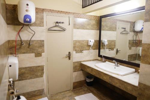 a bathroom with a sink and a mirror at The Monterey Grand Hotel in Lahore